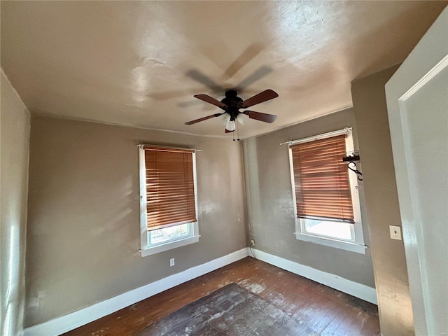 unfurnished room featuring ceiling fan and dark wood-type flooring