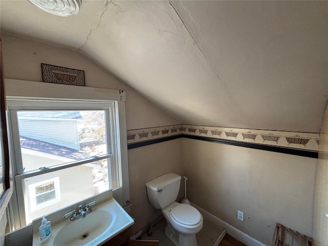 bathroom with vanity, vaulted ceiling, and toilet