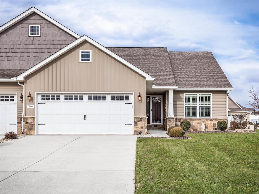 craftsman house featuring a garage and a front lawn