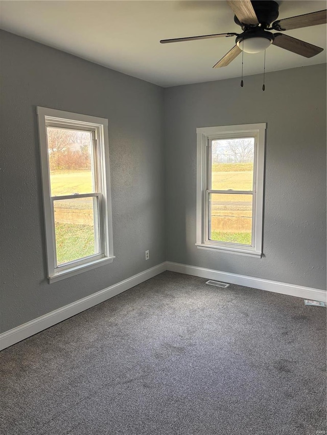 carpeted spare room with ceiling fan and a wealth of natural light