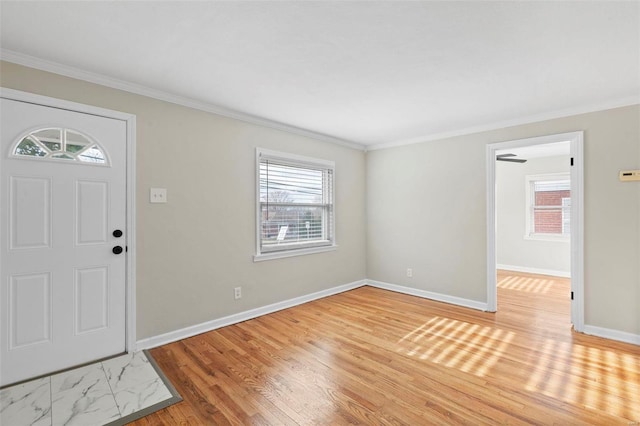 entryway with light hardwood / wood-style flooring, a healthy amount of sunlight, and ornamental molding