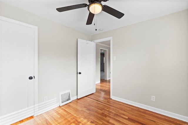 empty room with ceiling fan and light wood-type flooring