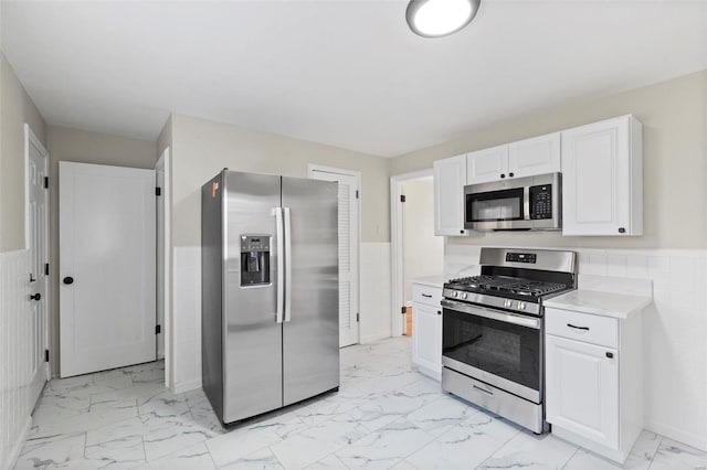 kitchen featuring white cabinets, tile walls, and appliances with stainless steel finishes