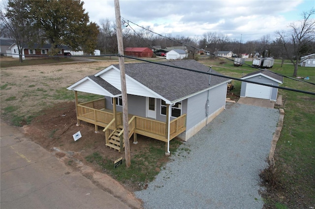 view of front facade with a porch, a garage, and an outbuilding