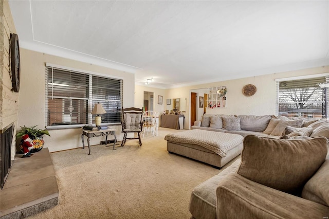 living room with a fireplace, light carpet, and crown molding