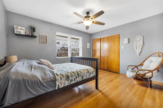 bedroom featuring hardwood / wood-style flooring, ceiling fan, and a closet