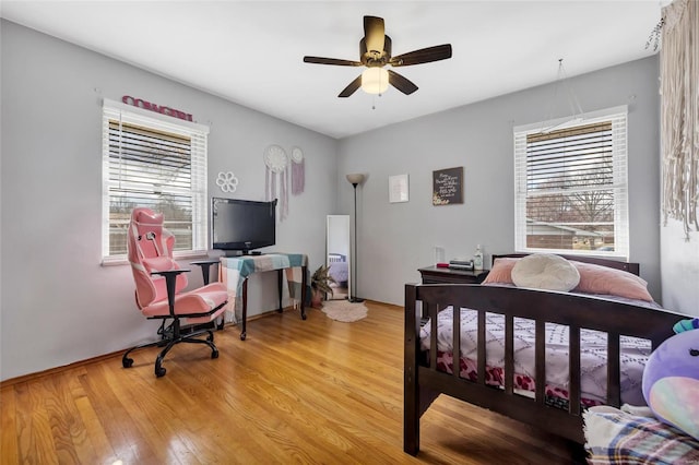 bedroom with light hardwood / wood-style floors, multiple windows, and ceiling fan