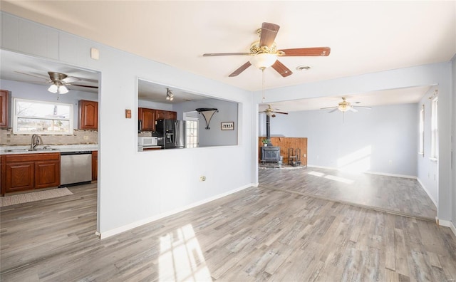 unfurnished living room featuring sink and light hardwood / wood-style flooring