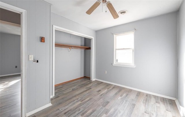 unfurnished bedroom featuring ceiling fan, light wood-type flooring, and a closet