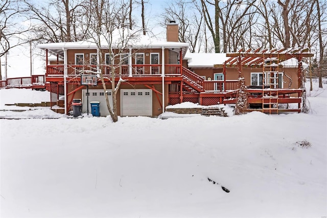 snow covered house with a pergola, a deck, a sunroom, and a garage