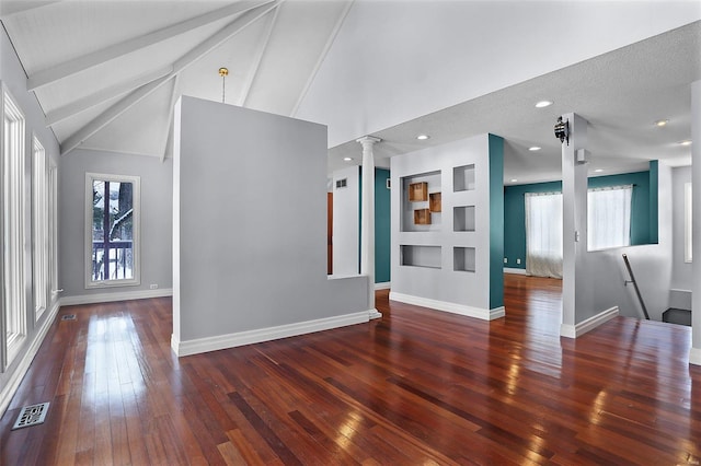 unfurnished living room featuring dark wood-type flooring and lofted ceiling with beams