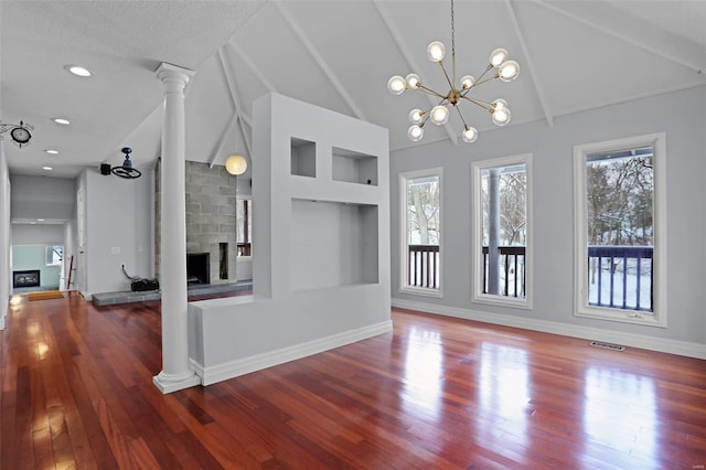 unfurnished living room with a fireplace, hardwood / wood-style flooring, a notable chandelier, and beam ceiling