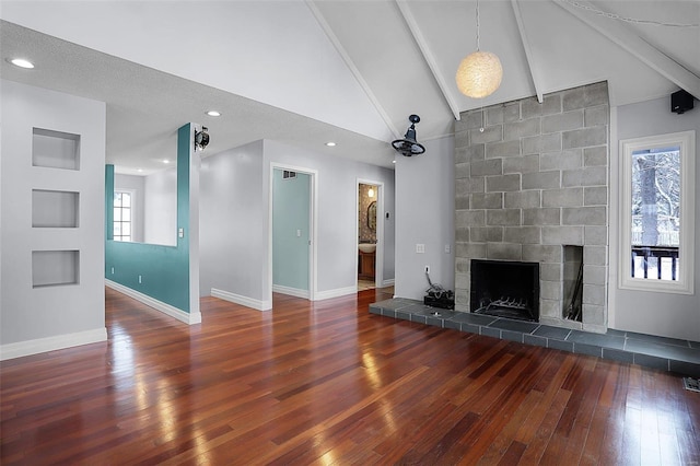 unfurnished living room with a tiled fireplace, high vaulted ceiling, beam ceiling, and dark hardwood / wood-style flooring