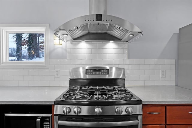 kitchen featuring extractor fan, decorative backsplash, and stainless steel gas range oven