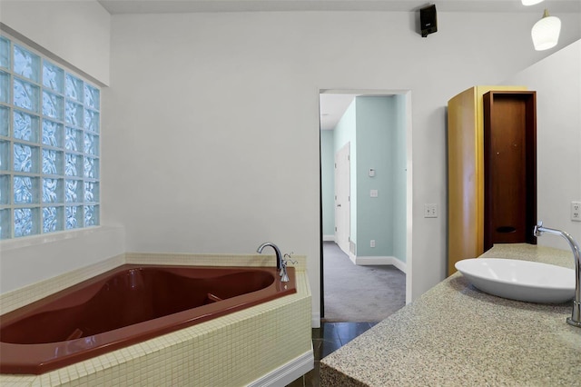 bathroom with sink and tiled tub