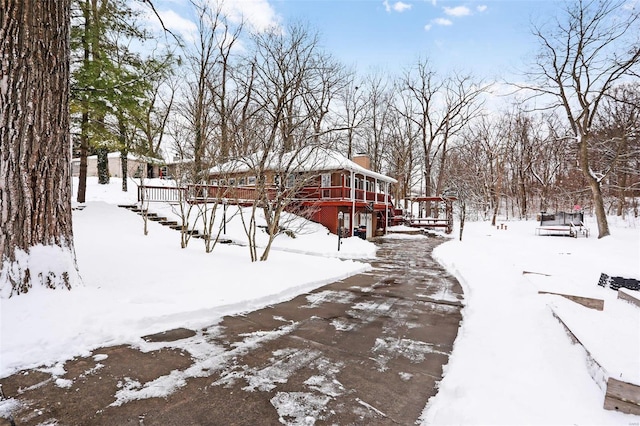 yard covered in snow featuring a deck