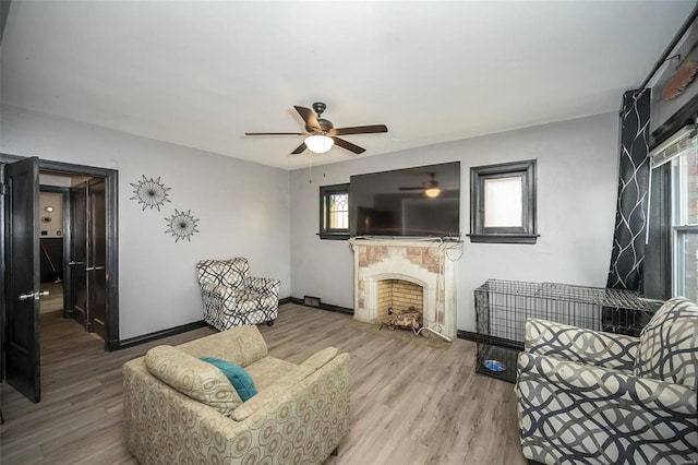 living room with ceiling fan, light wood-type flooring, and a wealth of natural light