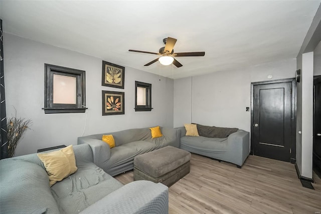 living room with light hardwood / wood-style floors and ceiling fan