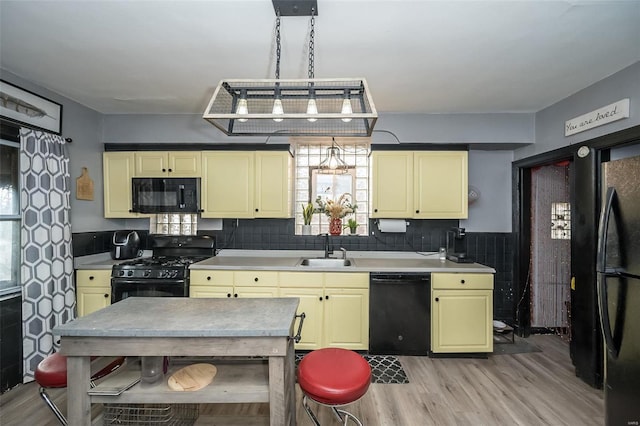 kitchen with sink, decorative light fixtures, a healthy amount of sunlight, and black appliances