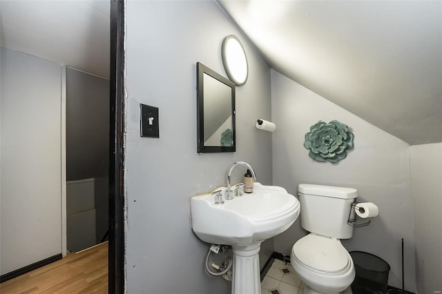 bathroom featuring hardwood / wood-style flooring, toilet, and vaulted ceiling