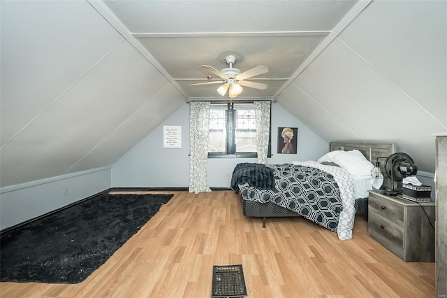 bedroom with ceiling fan, light hardwood / wood-style floors, and vaulted ceiling