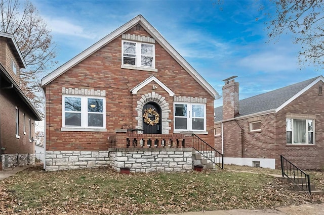 tudor home featuring brick siding