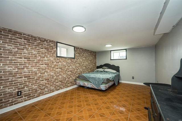 bedroom with brick wall and baseboards