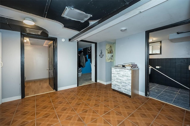 unfurnished bedroom with tile patterned flooring, baseboards, a walk in closet, and a closet