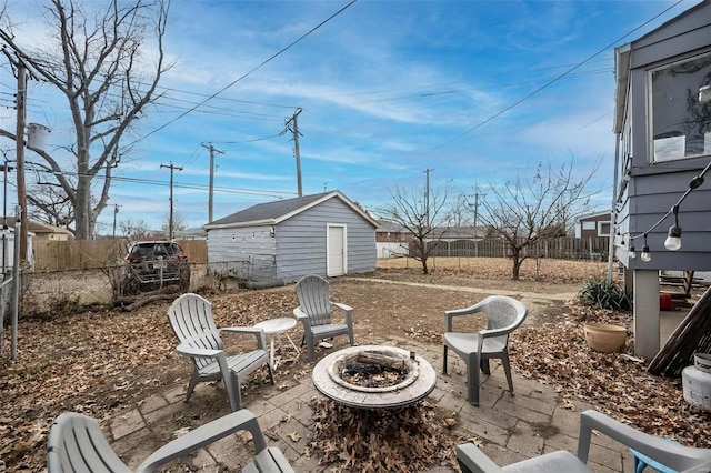 view of patio with an outbuilding, an outdoor fire pit, and fence