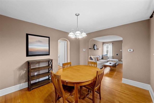 dining room featuring light wood-type flooring and a chandelier