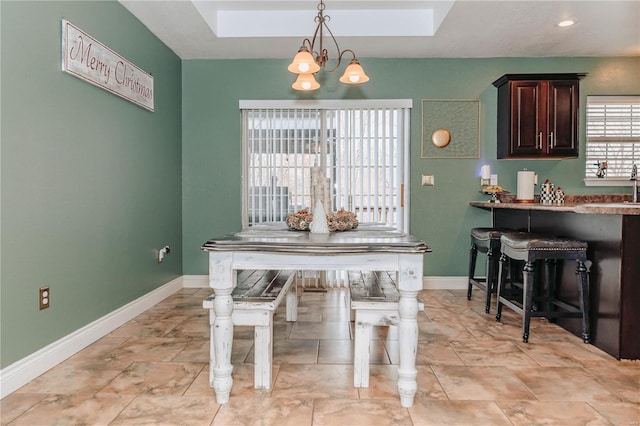 dining space with a chandelier and a skylight