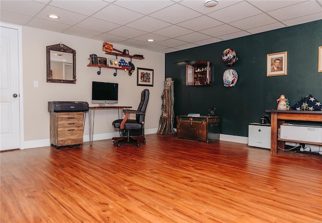 home office featuring hardwood / wood-style flooring and a drop ceiling