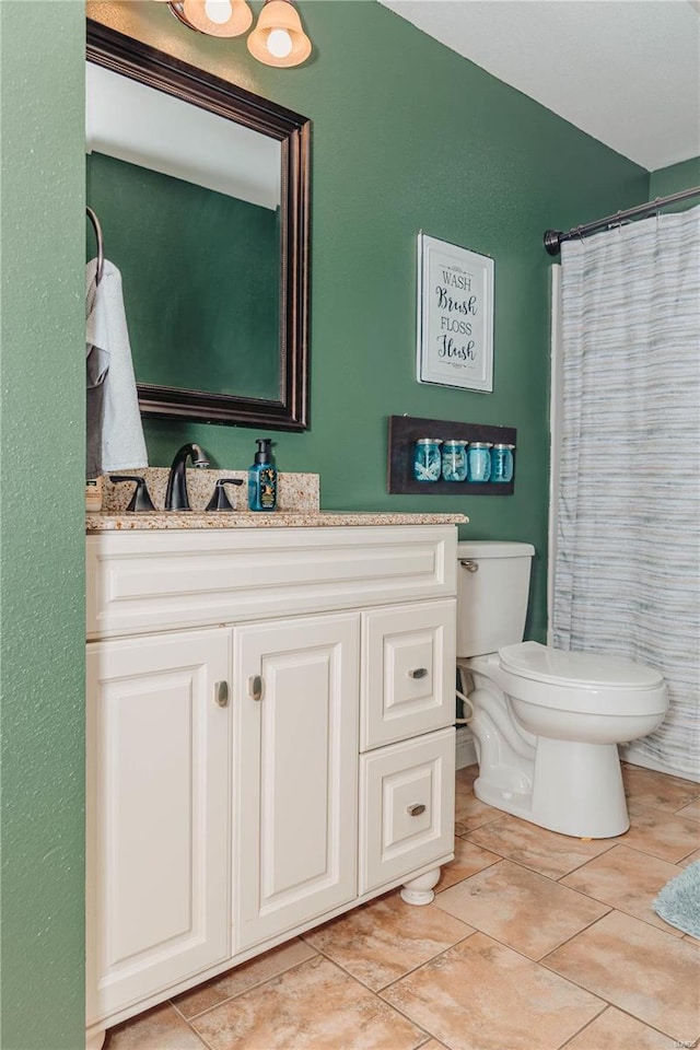 bathroom with vanity, tile patterned flooring, curtained shower, and toilet