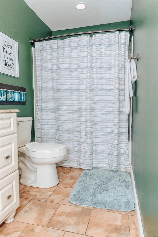 bathroom featuring vanity, curtained shower, tile patterned floors, and toilet