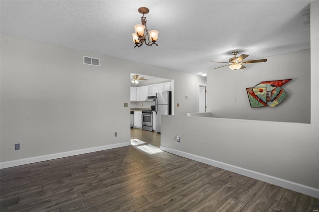 unfurnished living room with a textured ceiling, ceiling fan with notable chandelier, and dark hardwood / wood-style floors