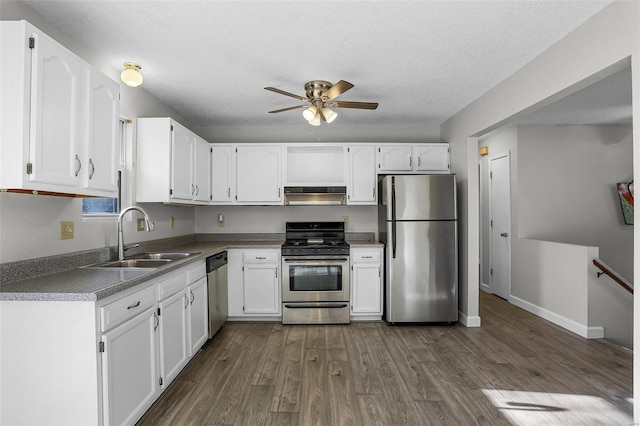 kitchen featuring white cabinetry, sink, stainless steel appliances, dark hardwood / wood-style floors, and exhaust hood