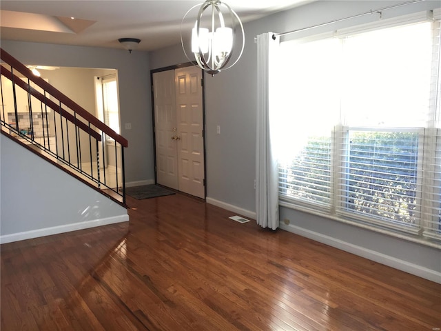 foyer entrance featuring dark hardwood / wood-style floors and an inviting chandelier