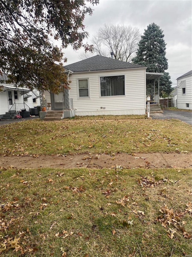 view of front of house featuring a front yard and cooling unit