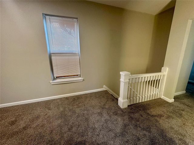 unfurnished room featuring dark colored carpet