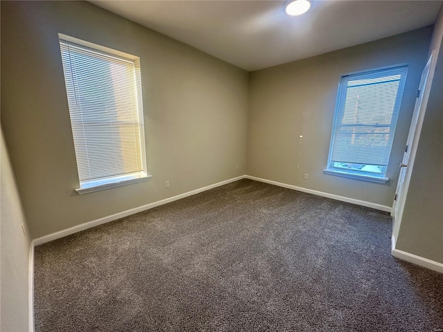 unfurnished room with dark carpet