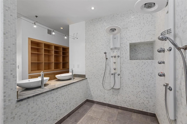 bathroom featuring tiled shower and sink