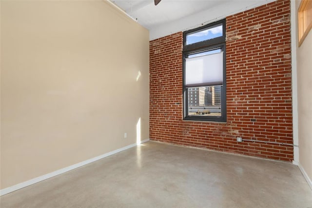 spare room featuring brick wall