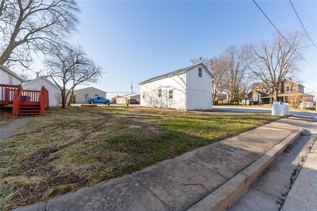 view of side of home with a wooden deck and a yard