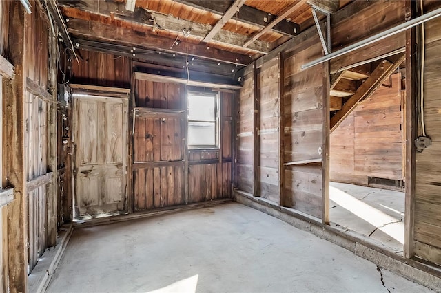 miscellaneous room with wooden walls and concrete flooring