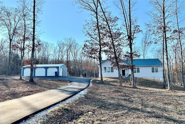 view of front of house with a garage and an outbuilding