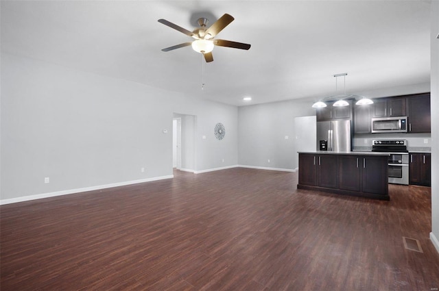 kitchen with a center island, appliances with stainless steel finishes, dark brown cabinetry, decorative light fixtures, and dark wood-type flooring