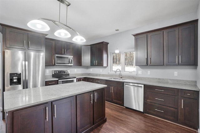 kitchen with sink, dark brown cabinets, hanging light fixtures, and appliances with stainless steel finishes