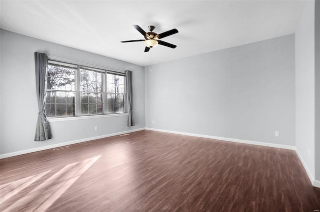 empty room featuring ceiling fan and dark hardwood / wood-style flooring