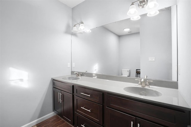 bathroom with hardwood / wood-style floors, toilet, and vanity