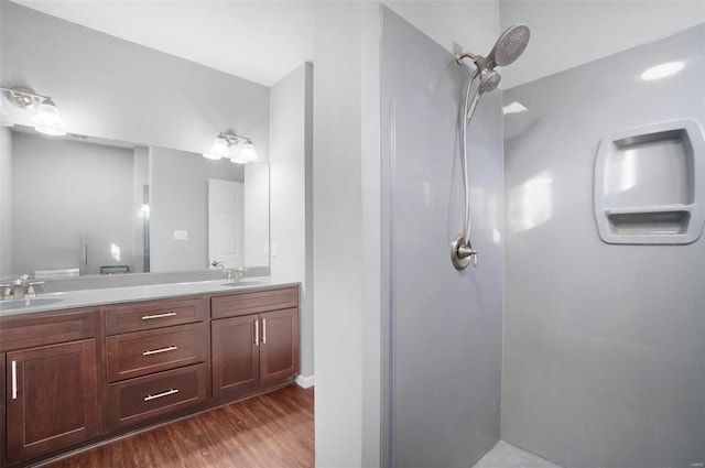 bathroom with wood-type flooring, a shower, and vanity